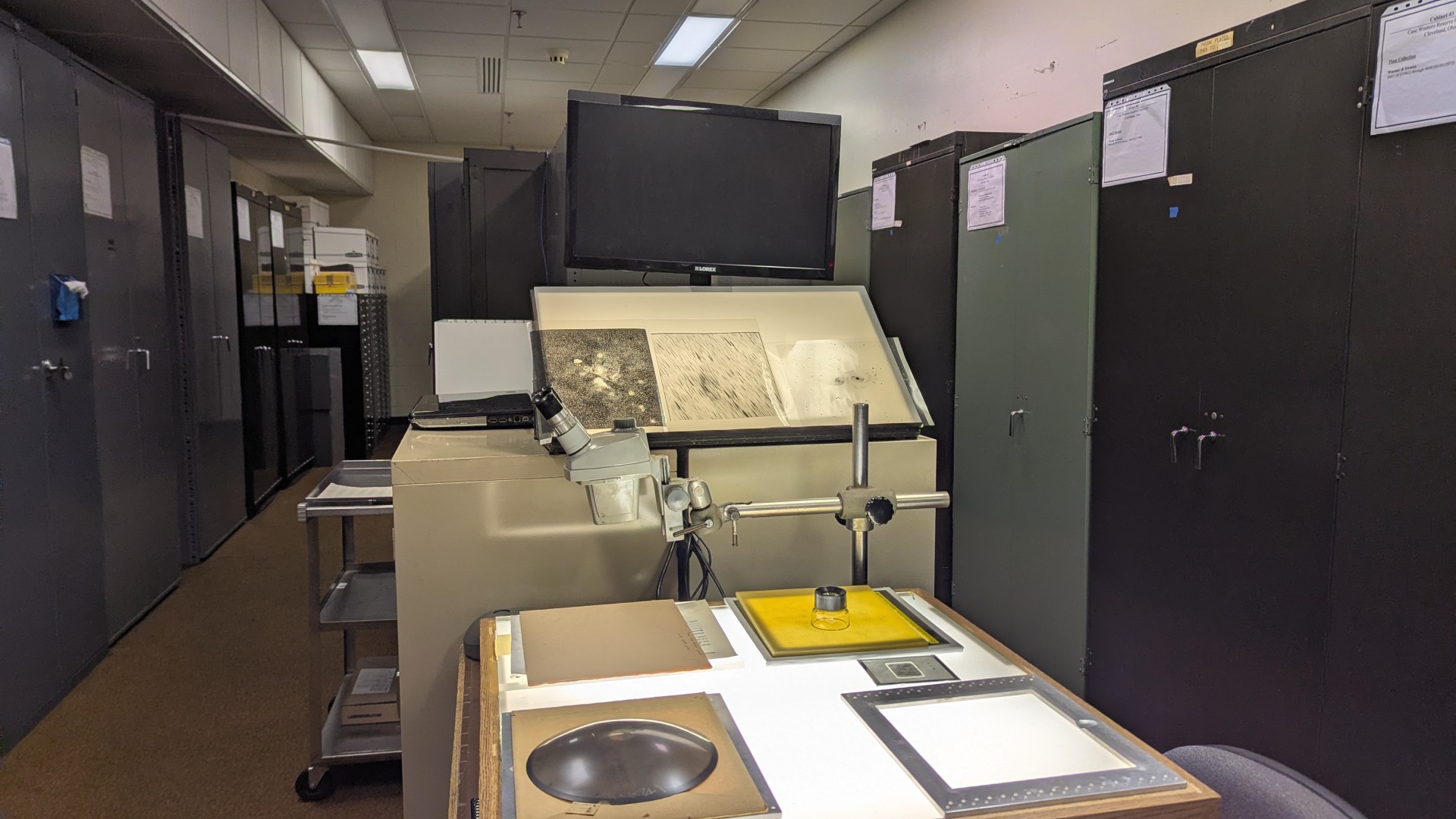 a table with an illuminated top sits in a room full of file cabinets