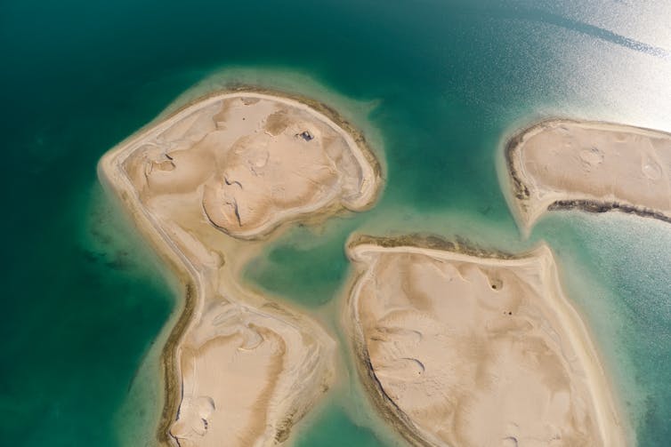 close up shot of sandy reclaimed islands and turquoise sea