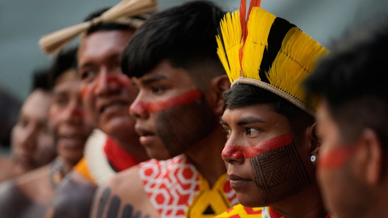 men wearing colourful headdress with painted faces