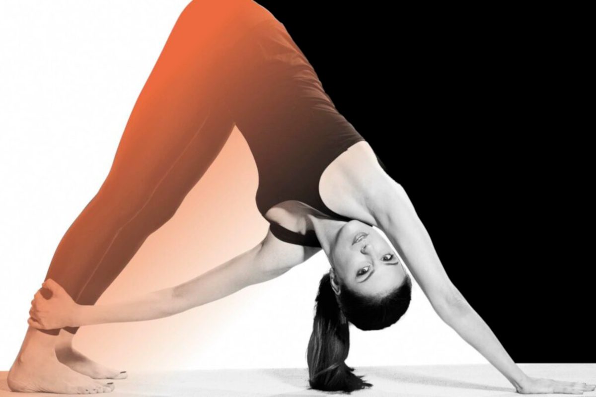 A person doing a yoga pose, arching their back into a triangle shape