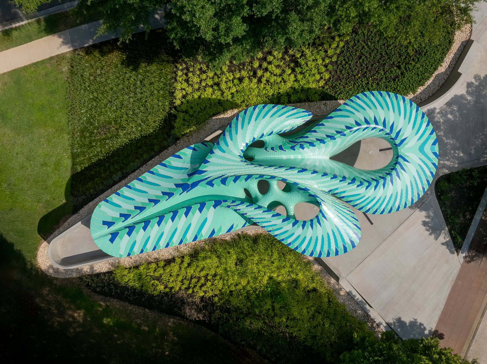an aerial view of a contemporary, teal-colored pavilion designed by Marc Fornes/THEVERYMANY in a public square in Knoxville, Tennessee