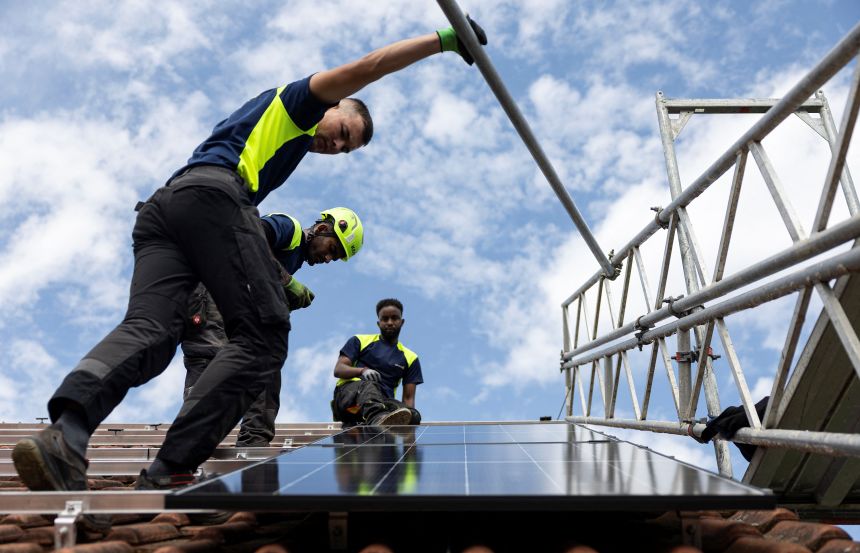Workers install solar panels near Marburg, in western Germany, on August 6, 2025.