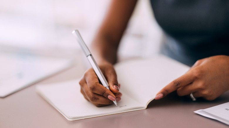 A man writing done notes for sideloading apps on TV