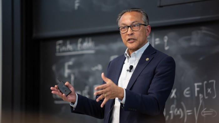 Ani Dasgupta speaks while gesturing during the 2024 Earth Day Colloquium, standing in front of a chalkboard.