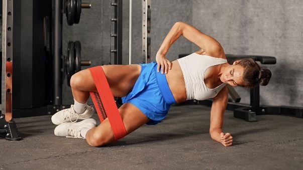 Woman works out using resistance band in gym environment