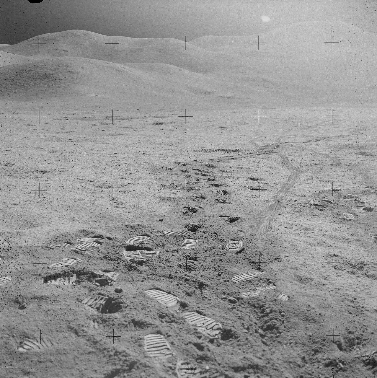 A black-and-white photograph of footprints on the surface of the Moon