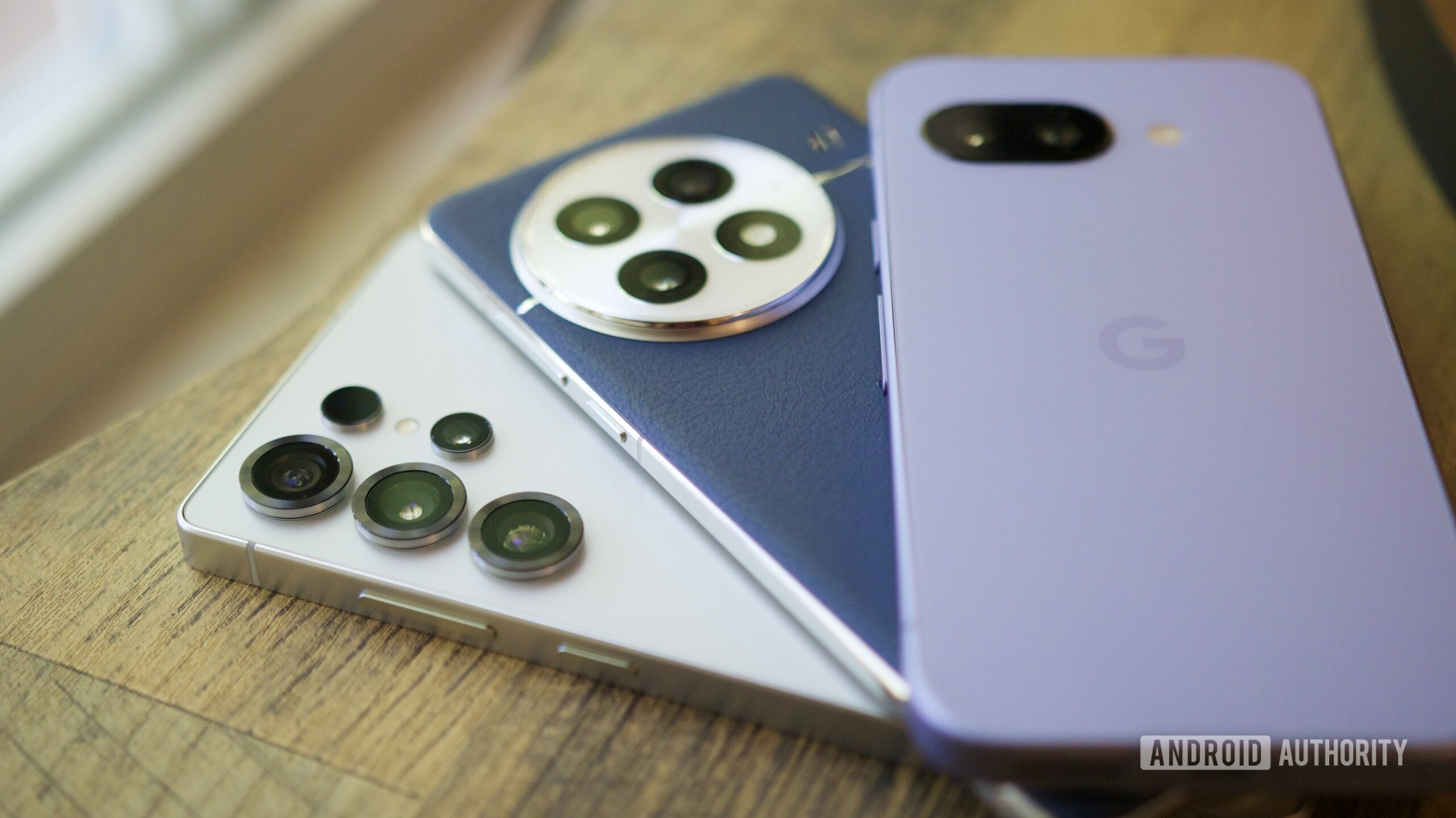 The Samsung Galaxy S25 Ultra, OnePlus 13, and Google Pixel 9a next to each other.