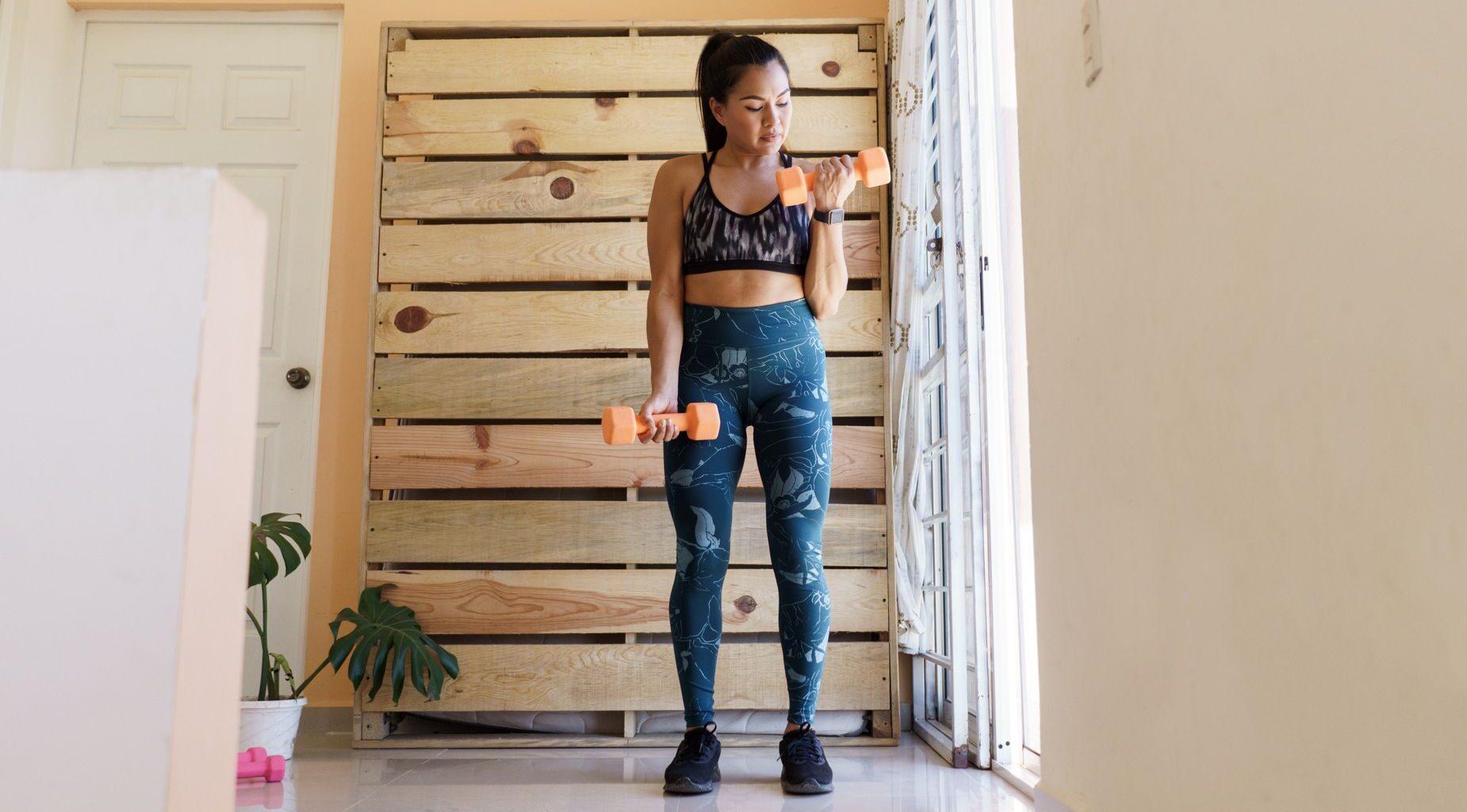Woman exercising with dumbbells at home
