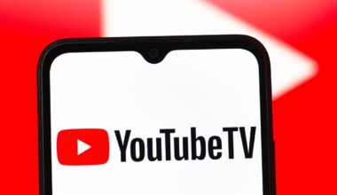 the YouTube TV logo on a mobile phone in front of a large red video play button in the background
