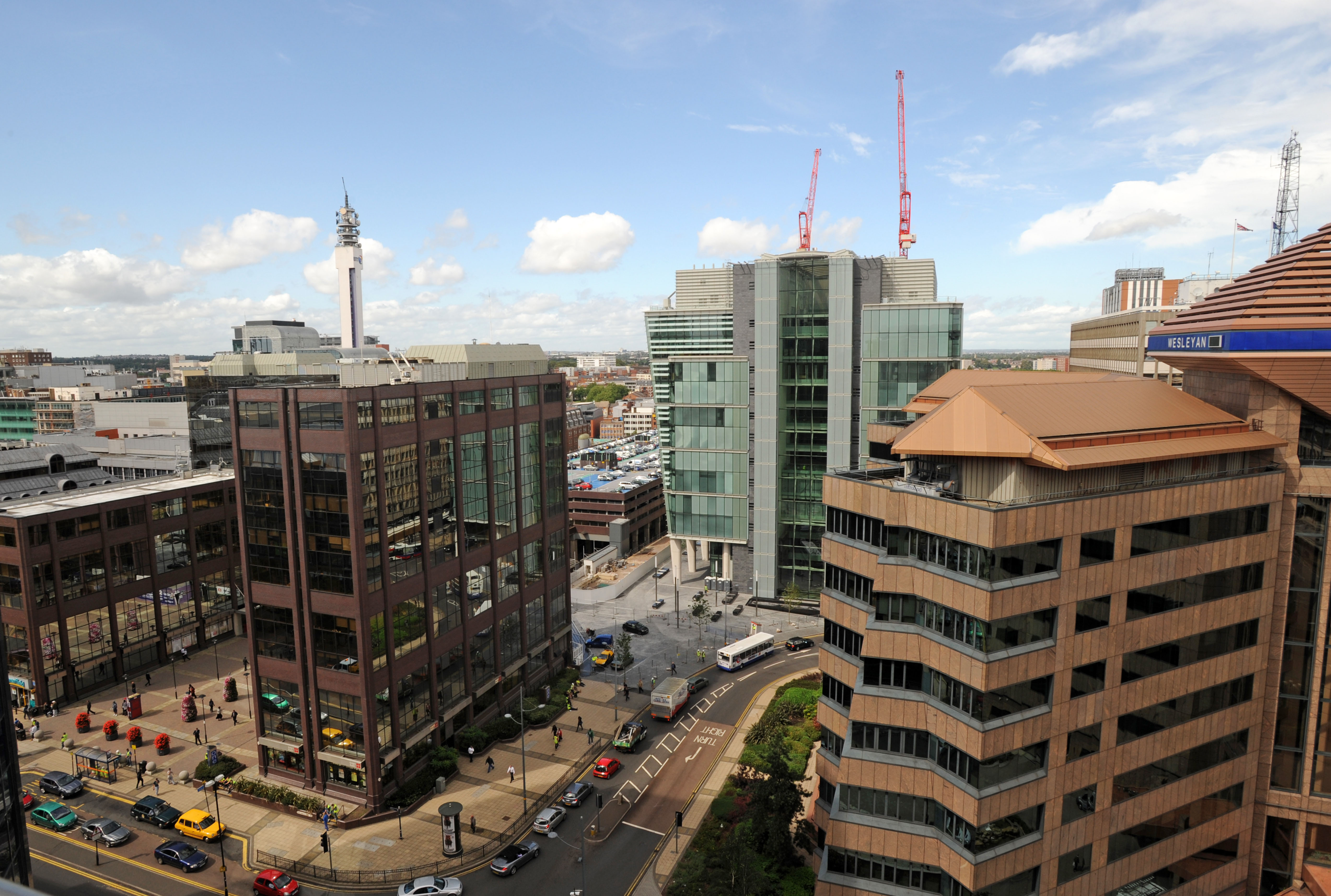 Colmore Circus in Birmingham, England, showing office buildings, city traffic, and the BT Tower in the distance.