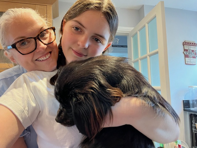 Mum Clare Neale and daughter Ruby Neale holding a small black dog.
