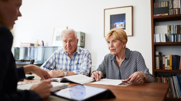 Senior couple listening to their female financial consultant at home. Elderly couple at home meeting with financial advisor.