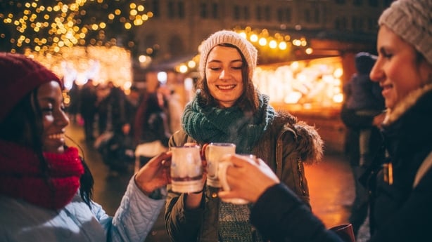 Photo of a cheerful friends having mulled wine on Christmas Market during Christmas Holidays