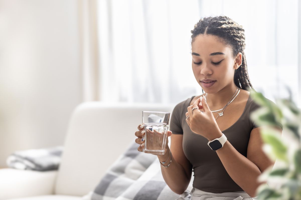 A woman takes a painkiller