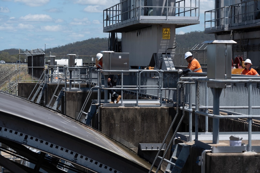 Workers in hi-vis on top of Wivenhoe dam wall