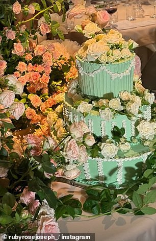 A three-tier, mint-coloured wedding cake was adorned with flowers