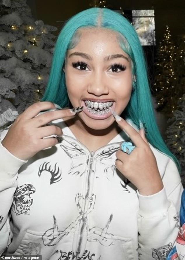 North West, the daughter of Kim Kardashian and Kanye, shows off her diamond shark teeth