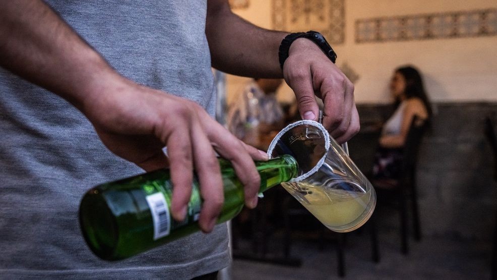 FILE - A waiter pours a beer into lime juice to make a cocktail for customers in a bar in the old town in Damascus on June 19, 2025. (Photo by Ed Ram/Getty Images)