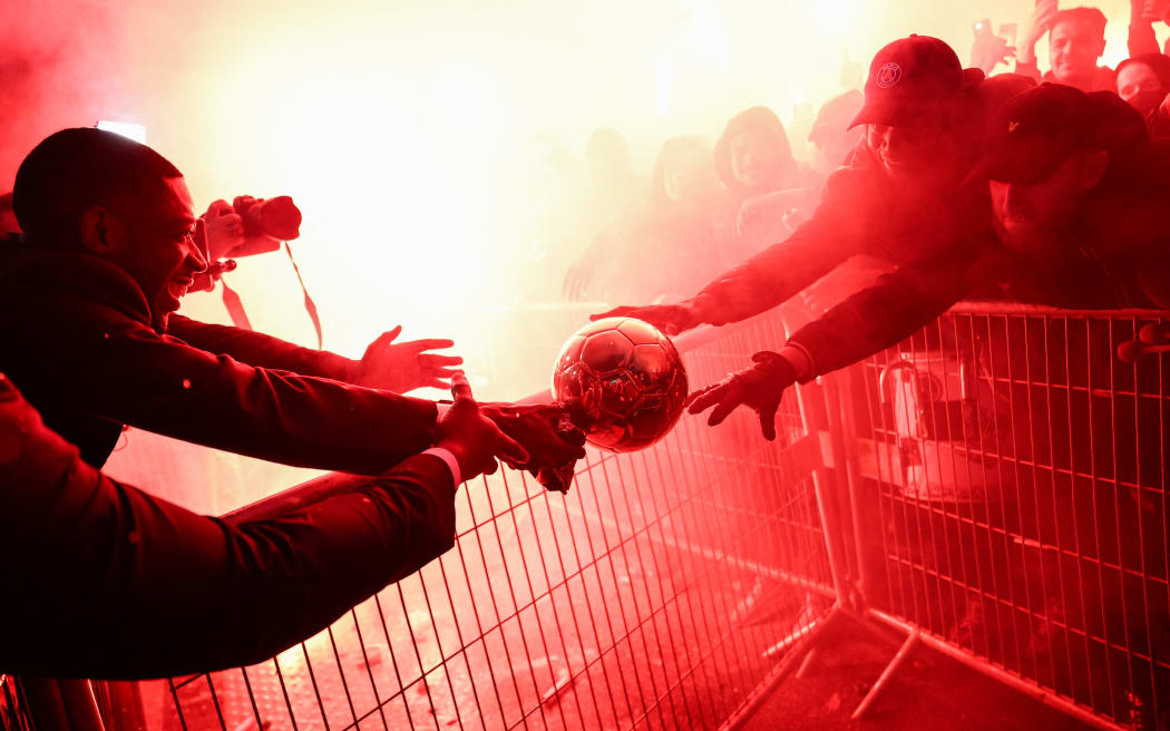 Paris Saint-Germain's French forward Ousmane Dembele celebrates with supporters after receiving the Ballon d'Or award at the end of the 2025 Ballon d'Or France Football award ceremony outside the Theatre du Chatelet in Paris on September 22, 2025.