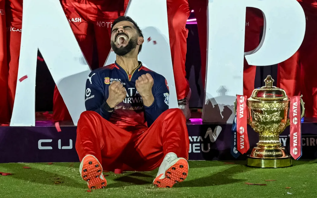 Royal Challengers Bengaluru's Virat Kohli reacts while sitting beside the trophy after winning the Indian Premier League (IPL) Twenty20 final cricket match against Punjab Kings at the Narendra Modi Stadium in Ahmedabad on June 4, 2025. (Photo by Arun SANKAR / AFP) / -- IMAGE RESTRICTED TO EDITORIAL USE - STRICTLY NO COMMERCIAL USE --