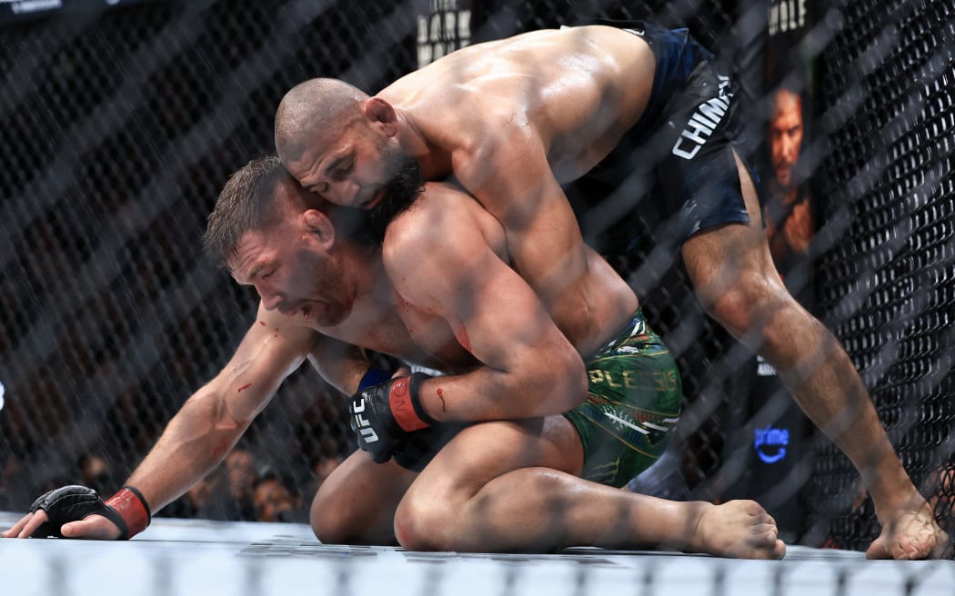 Khamzat Chimaev of the United Arab Emirates grapples with Dricus du Plessis of South Africa during their middleweight title bout in UFC 319.