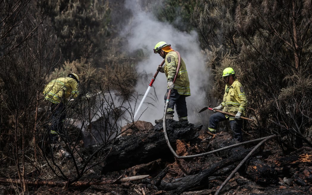 170224 CHRIS SKELTON / POOLFirefighters continue their efforts on Saturday as they work to dampen down remaining hot spots and create a buffer zone around the 24km perimeter fire ground in Christchurch's Port Hills. Pictured left to right, Lee Reihana (City Care firefighter), John Hytongue (City Care firefighter), and Stephen Robson (Peel Forest Volunteer firefighter)
