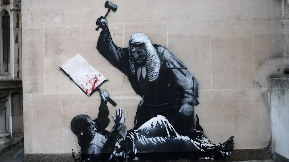 Mural of a judge attacking an apparent protestor lying on the ground holding a blood splattered placard, with a gavel.