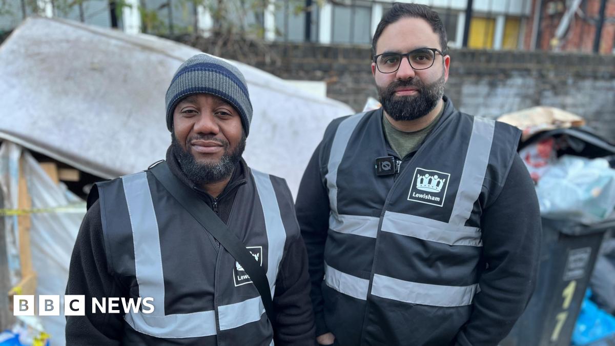 Alain N'Guessan Bi and Eiman Rostami wearing dark Lewisham clothing. They are standing in front of overfilling bins and a stained mattress