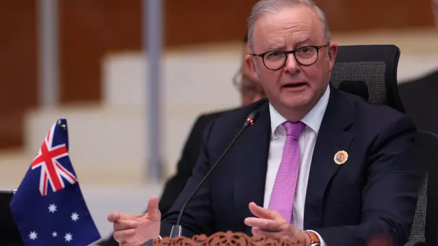 Australian Prime Minister Anthony Albanese sat next to an Australian flag