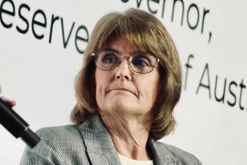 A woman with a pair of glass at an annual dinner