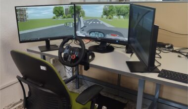 Driving simulator setup used in the experiments, consisting of a steering wheel with pedals, three monitors displaying the virtual driving environment, and a participant’s chair. Study: Cognitive alterations related to driving performance in Parkinson’s disease detected by a driving simulator 