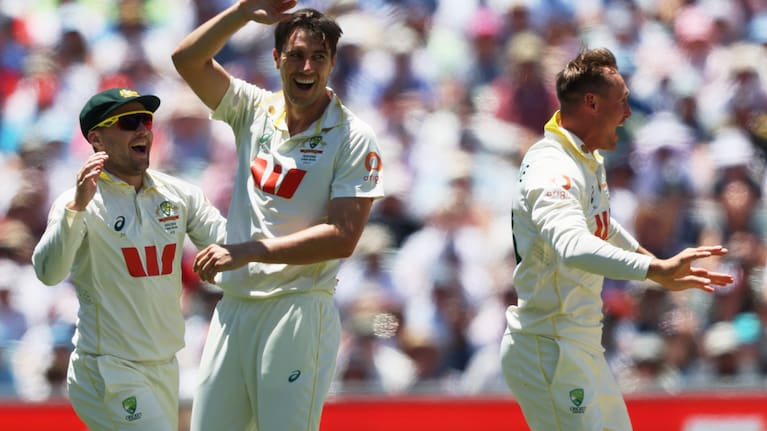 Australia's Pat Cummins, centre, celebrates with teammate Australia's Marnus Labuschagne, right, after dismissing England's Ollie Pope during play on day four of the third Ashes cricket test between England and Australia in Adelaide, Australia.