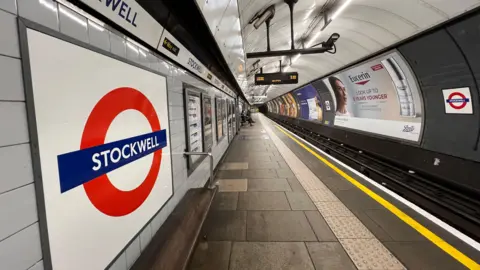BBC/Harry Low Red and white Tube roundel on empty platform at Stockwell station
