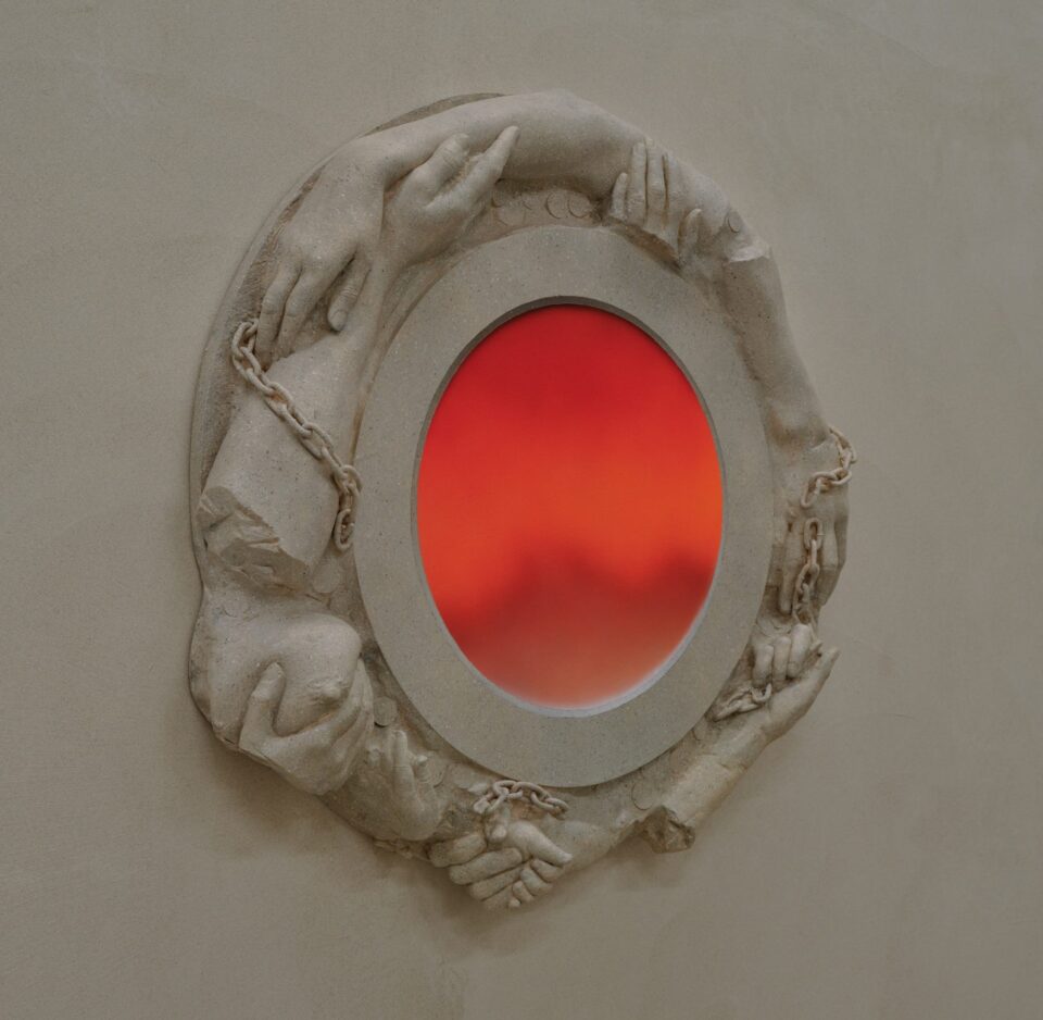 An art installation by Clementine Keith-Roach and Christopher Page of plaster-cast hands in a circle around a red portal-like painting