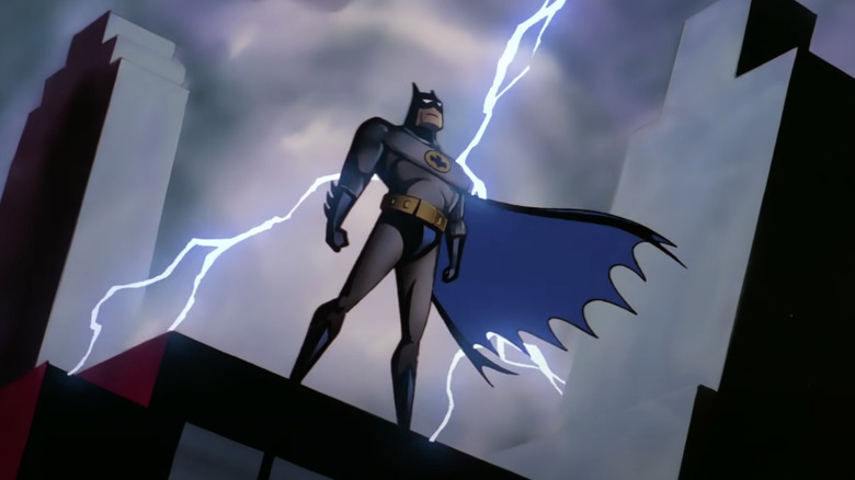 Batman stands on a building with lightning striking behind him in Batman: The Animated Series