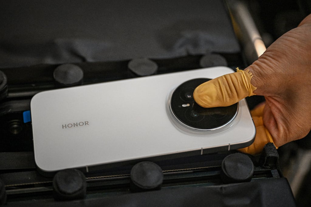 A worker on a production line holds an Honor Magic 8 smartphone at a factory in Shenzhen in October. Photo: AFP