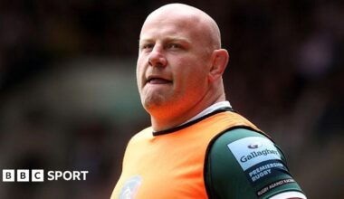 Dan Cole wearing an orange bib over a green Leicester Tigers shirt