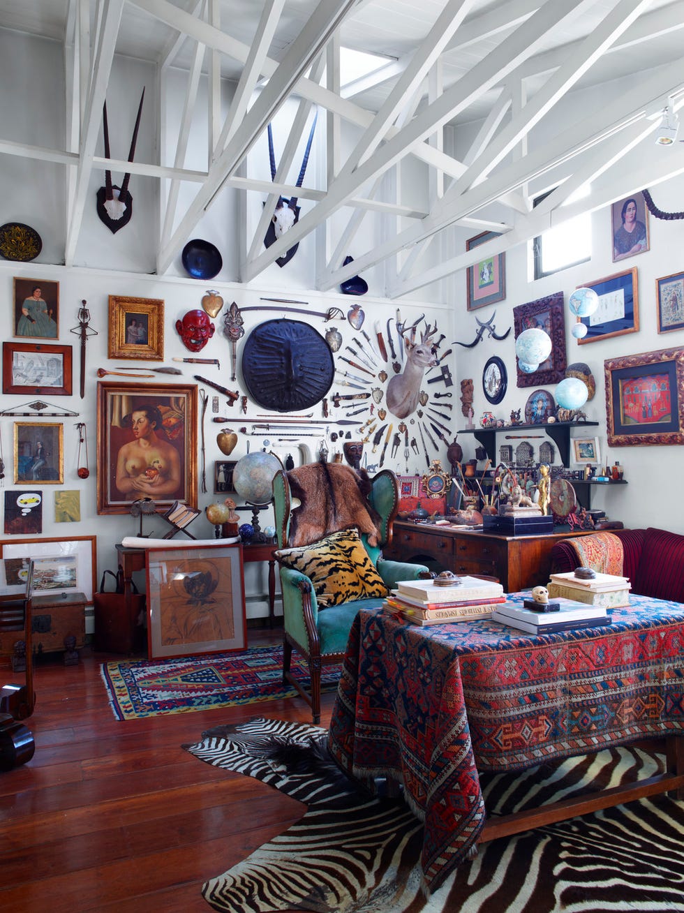 A cluttered and eclectic room filled with various artworks and decorative objects