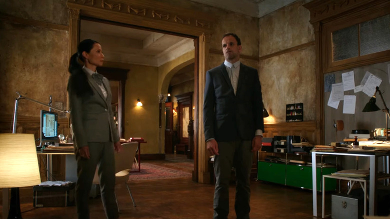 Lucy Liu's Dr. Joan Watson looking at Jonny Lee Miller's Sherlock Holmes in Elementary