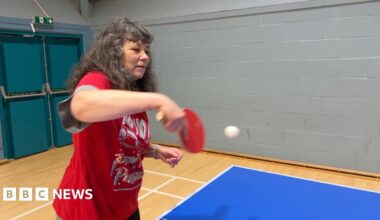 A woman in a red Christmas top returns the ball during a table tennis session organised by Sport in Mind.