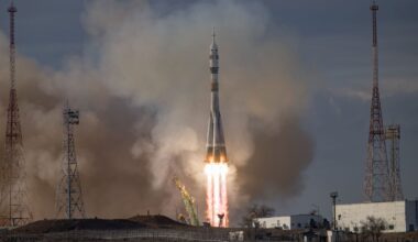 A Soyuz rocket taking off from a launchpad in daylight hours