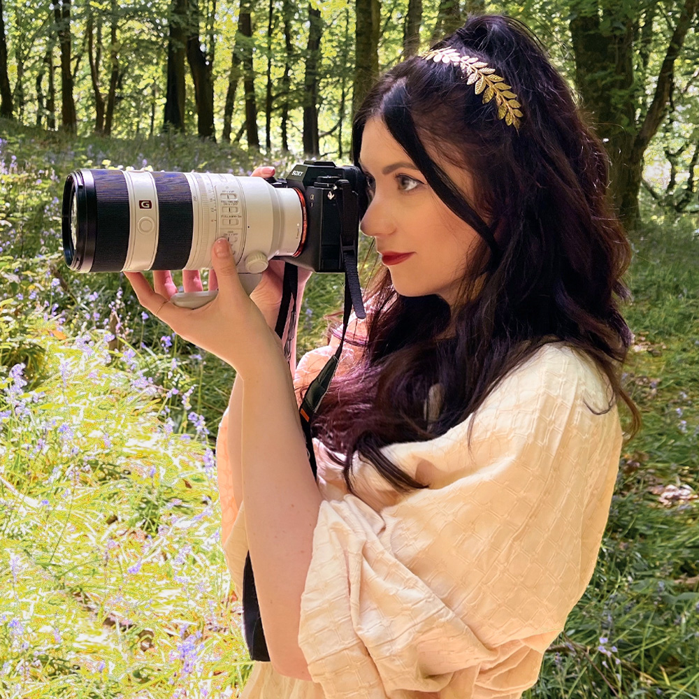 woman using a camera in a woodland