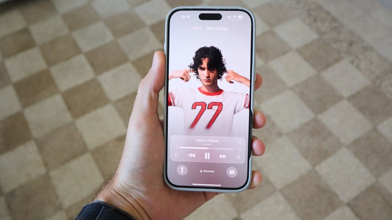 iOS 26 Lock Screen with Apple Music dynamic cover