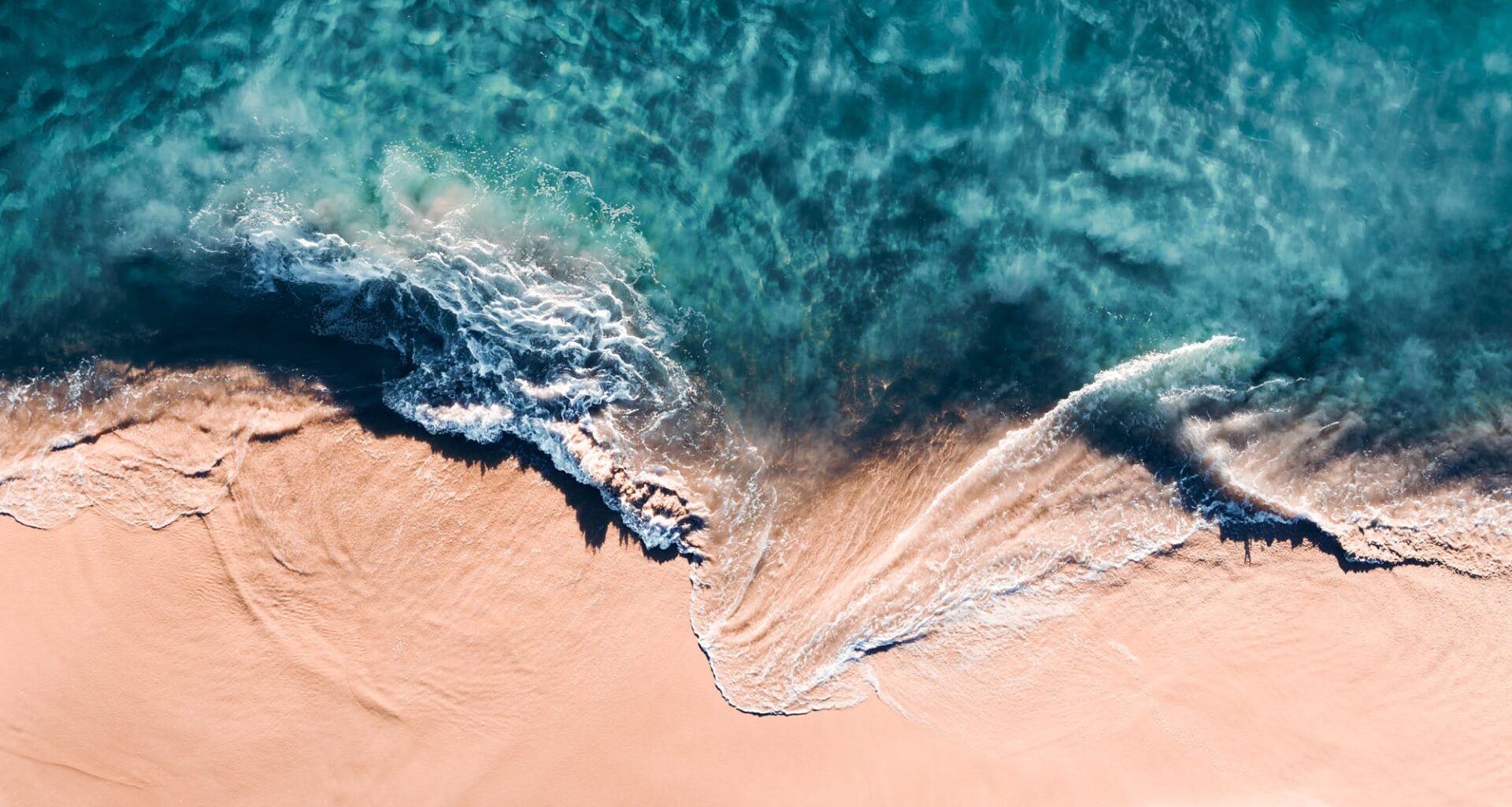An aerial view of crashing waves shot at a vertical angle by Kevin Krautgartner