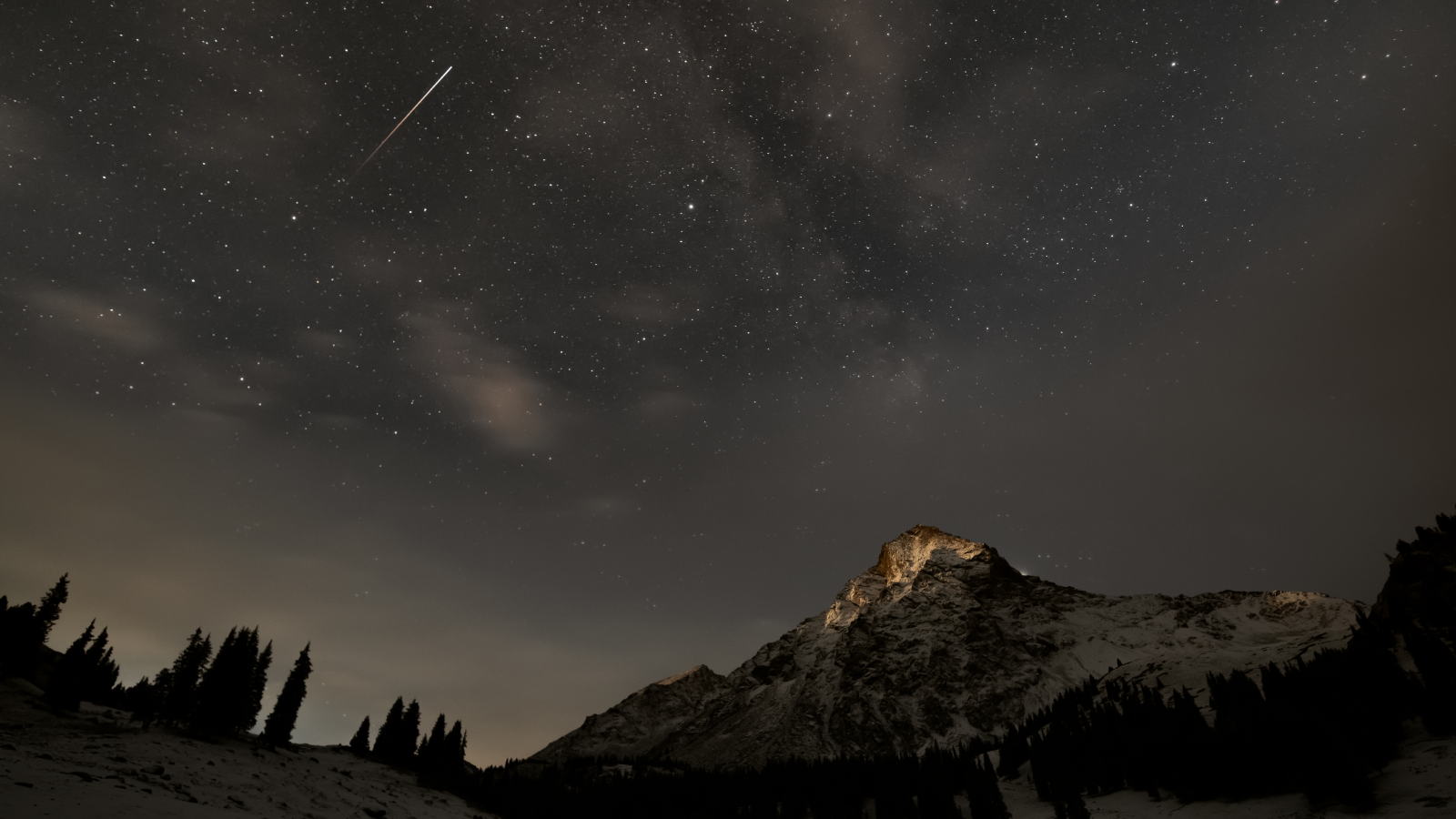 Shooting star above a snow mountain.