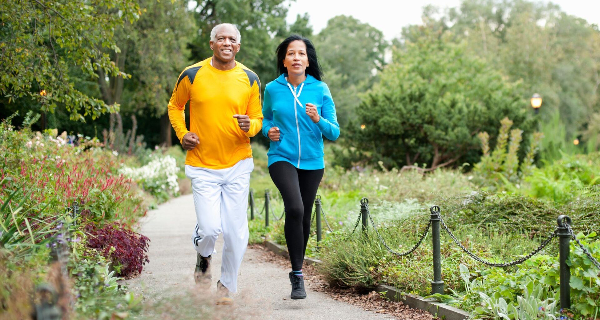 older couple run together in a park