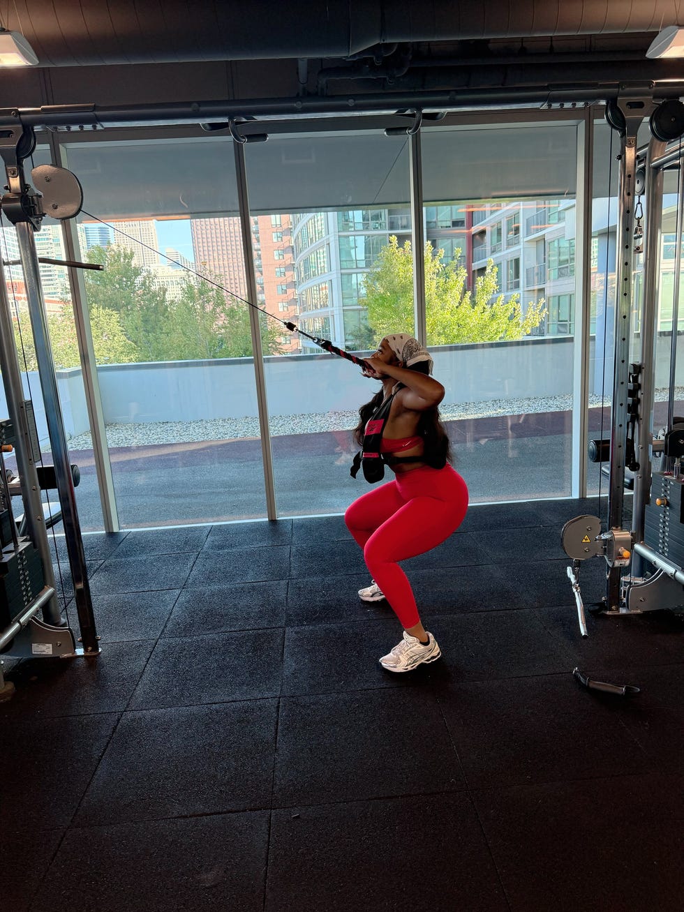 Individual performing a squat exercise with resistance bands in a gym individual performing a squat exercise with resistance bands in a gym