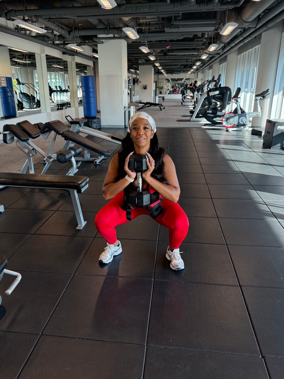 Individual performing a squat exercise in a gym setting individual performing a squat exercise in a gym setting