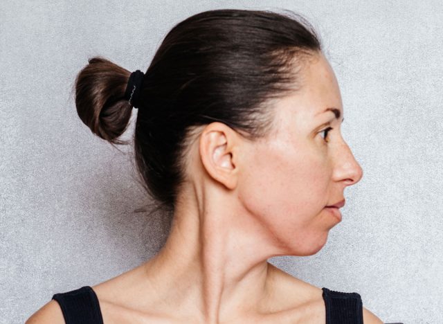 McKenzie method exercise to relieve neck pain, a woman gently rotates her head while doing neck pain relief exercises