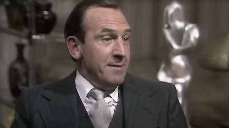 Leonard Rossiter as Reginald in The Fall and Rise of Reginald Perrin, attempting to ask his boss for a holiday.